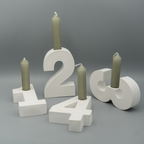 Vier Adventszahlen 1 bis 4 aus weißem Gießpulver dienen als Kerzenhalter. In jeder Zahl steckt eine graugrüne Stabkerze, die noch nicht angezündet ist. Die Zahlen sind dekorativ vor einem grauen Hintergrund arrangiert.